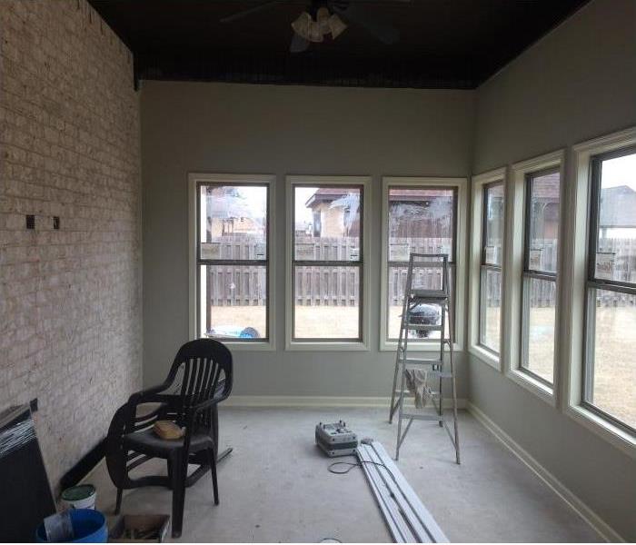 sun room with three windows on each wall, construction in process, cement floors