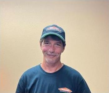 male standing against wall smiling with SERVPRO shirt on