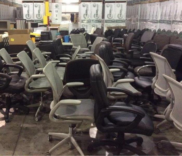 grey adn black roller office chairs stored in warehouse
