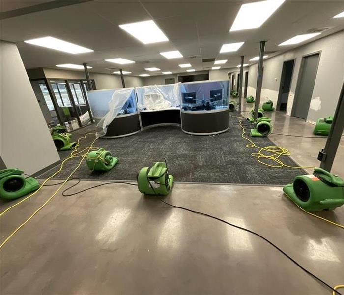 office building with desk in the middle. 14 SERVPRO dryers on the floor surrounding the large office