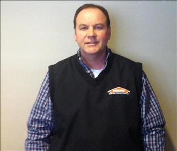 male with plaid shirt and black SERVPRO® vest