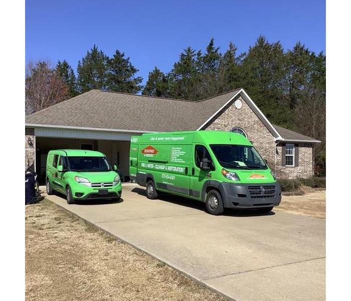 SERVPRO vans in the driveway of a home